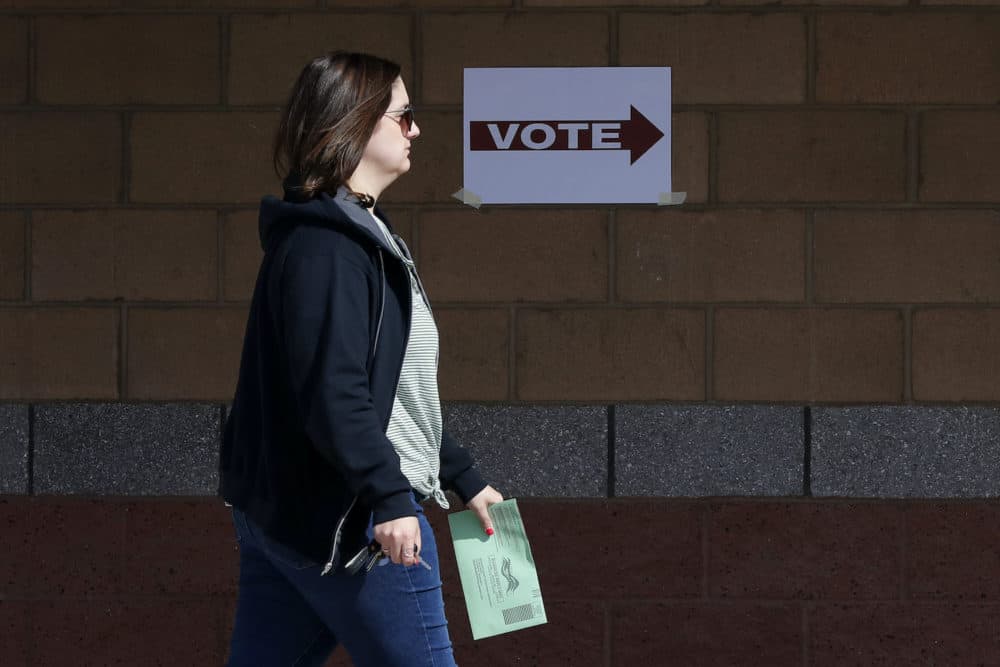 An Arizona voter delivers her mail-in ballot at a polling station for the Arizona presidential preference election in Phoenix. (Matt York/AP Photo)