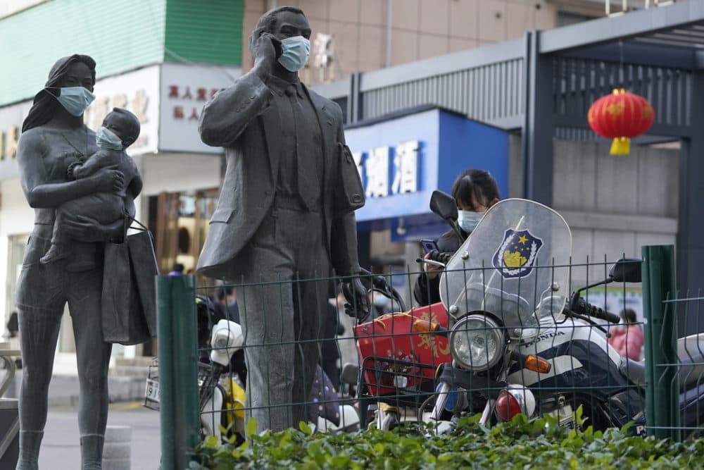 Statues along a street are seen with masks placed on them as a WHO mission visits Wuhan in central China's Hubei province. (Ng Han Guan/AP)