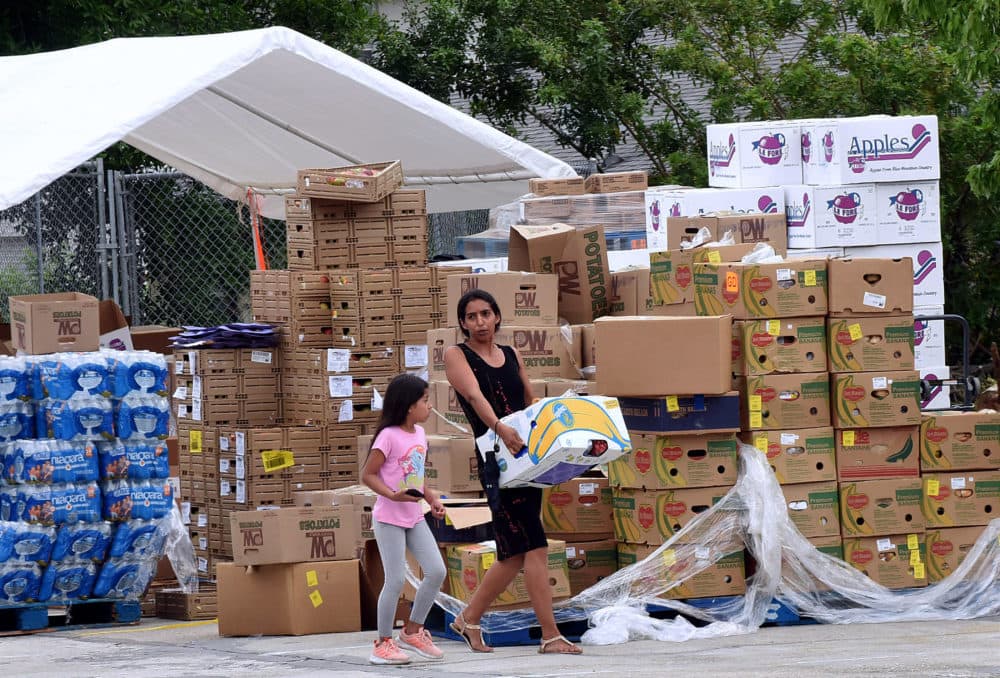 A woman with a child carries a box of food assistance she received from the Second Harvest Food Bank of Central Florida. (Paul Hennessy/NurPhoto via Getty Images)
