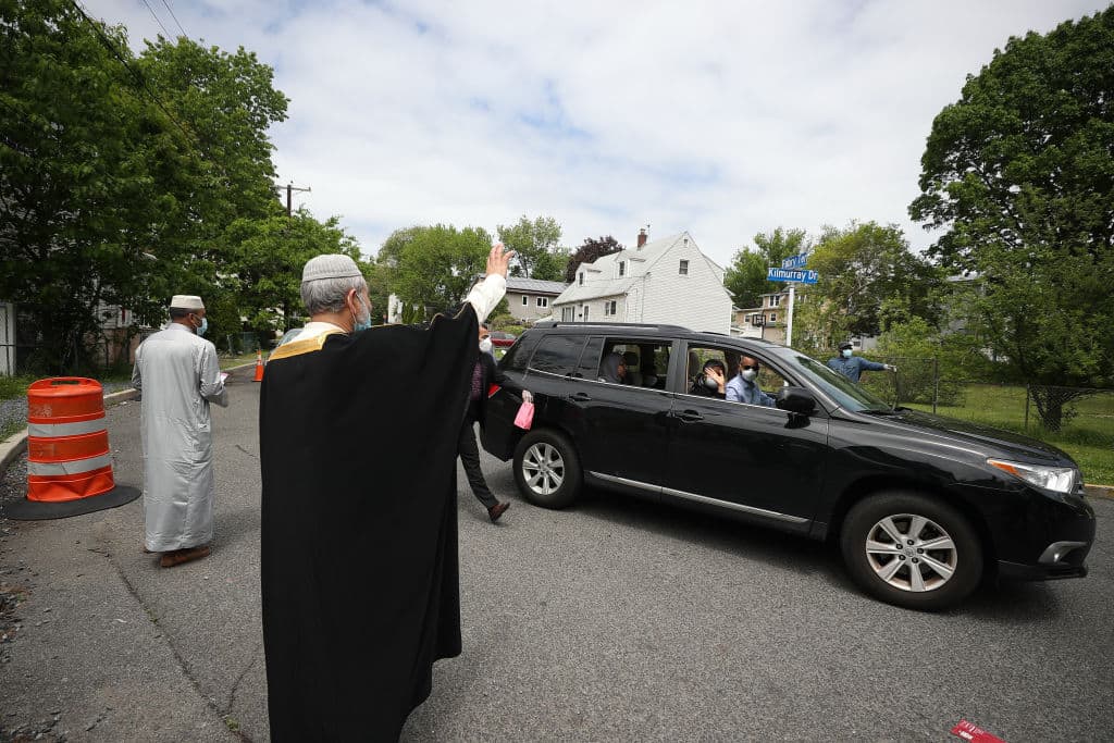 An imam greets people who lined up in their cars at the Daruh Islah mosque in Teaneck, New Jersey, in May 2020 to celebrate Eid al-Fitr during the pandemic. (Tayfun Coskun/Anadolu Agency via Getty Images)
