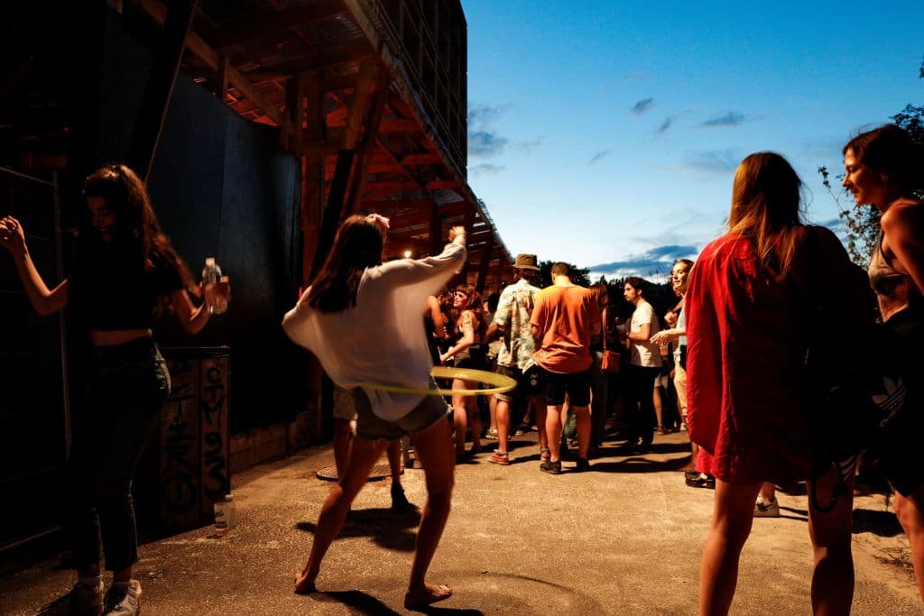 A woman hula-hoops among people enjoying an open air party in Saint-Denis, north of Paris on Aug. 1, 2020. (Geoffroy van der Hasselt/AFP via Getty Images)