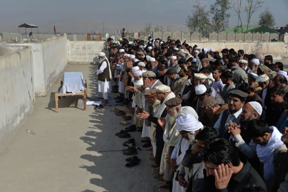 Relatives and mourners perform funeral prayers over the coffin of one of the three female media workers shot to death in Jalalabad on March 3, 2021. (Noorullah Shirzada/AFP/Getty Images)