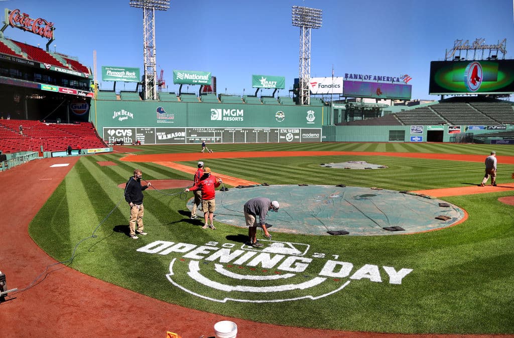 A worker spray-paints "Opening Day" behind home plate at Fenway Park in Boston on March 30, 2021. (John Tlumacki/The Boston Globe via Getty Images)