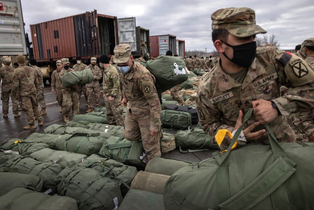 Army soldiers retrieve their duffel bags after they returned home from a nine-month deployment to Afghanistan on Dec. 10, 2020 at Fort Drum, New York. (John Moore/Getty Images)