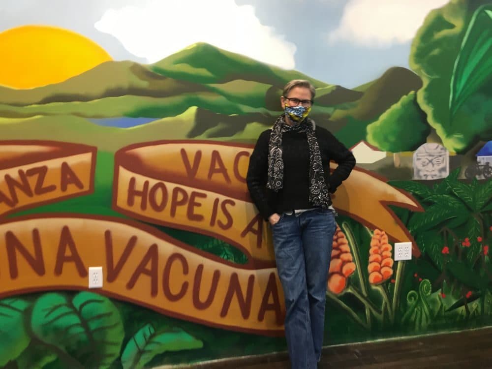 Dr. Annie De Groot, volunteer medical director at Clinica Esperanza, in front of a mural at the storefront clinic on Valley Street in Providence, R.I.(Lynn Arditi/The Public's Radio)