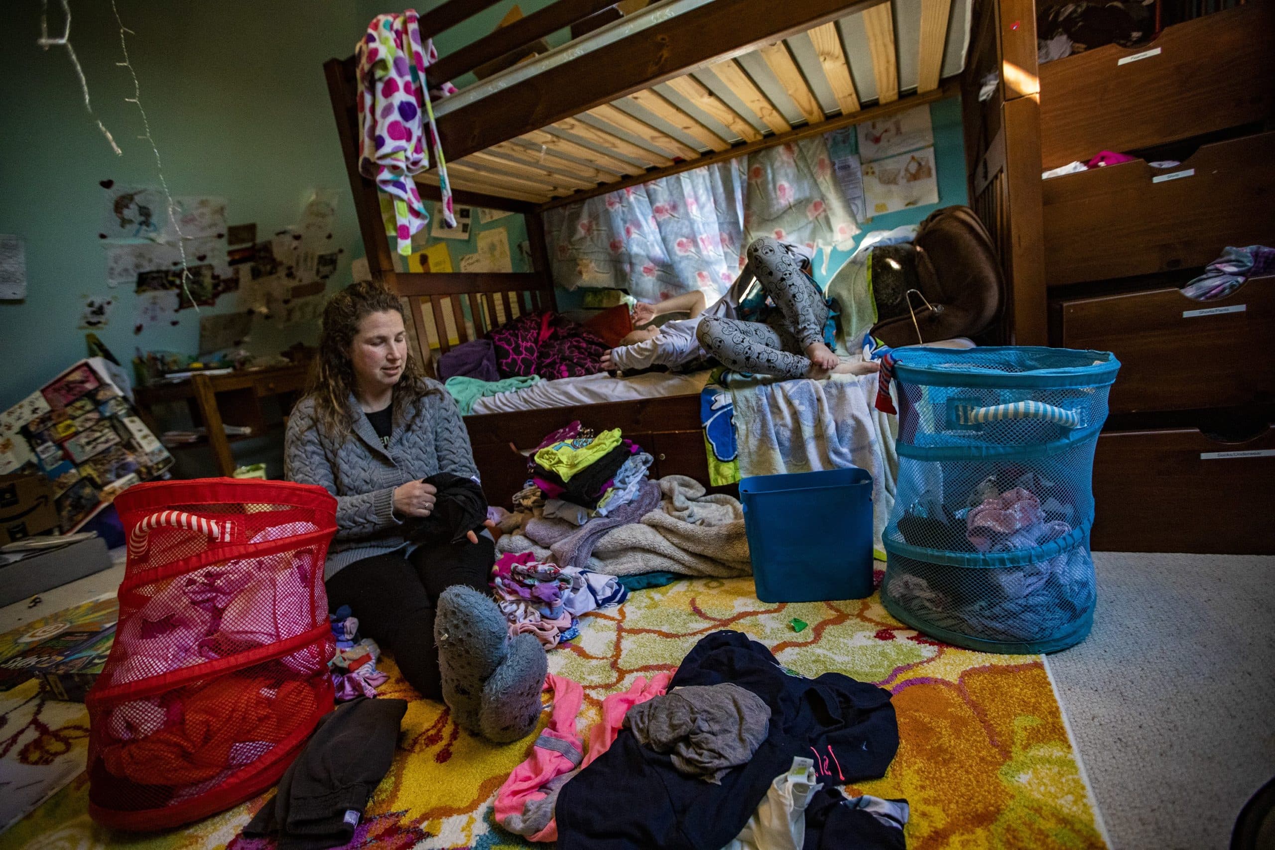 Hallel and their mother talk in Hallel’s room while doing an inventory of their clothes. (Jesse Costa/WBUR)