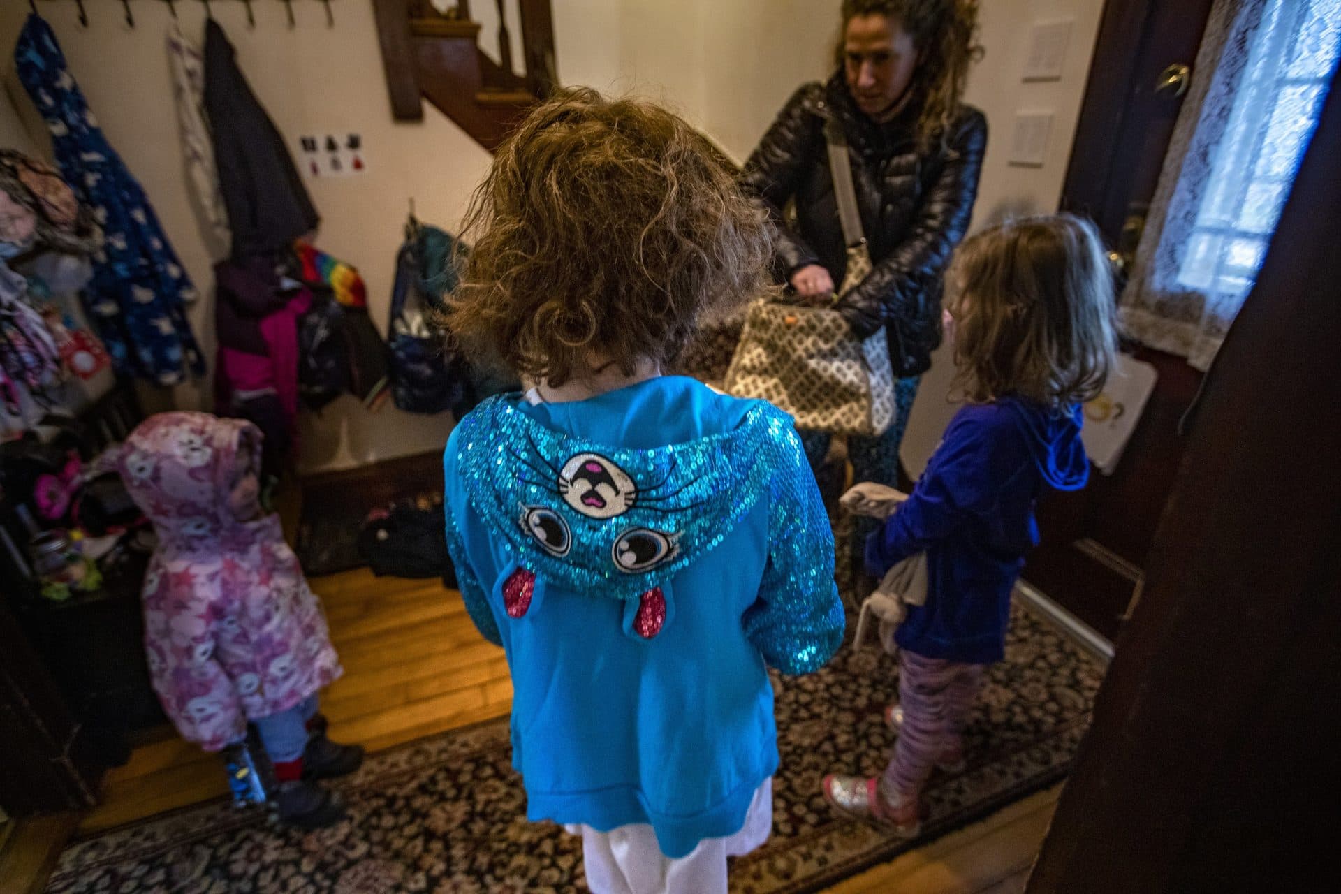 The family gathers in the entryway of their house before heading out to the playground. (Jesse Costa/WBUR)
