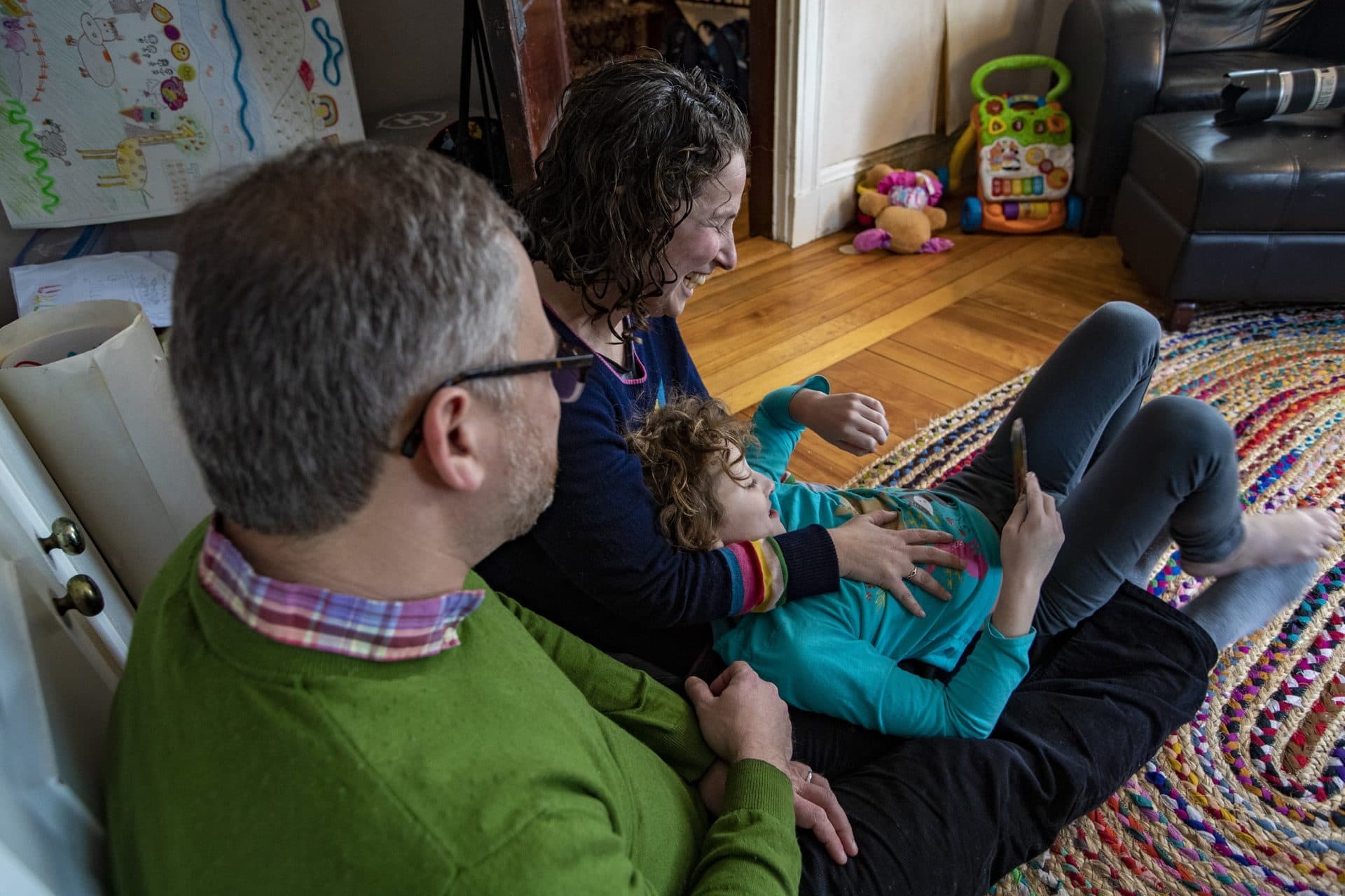 The family sits together in the living room. (Jesse Costa/WBUR)