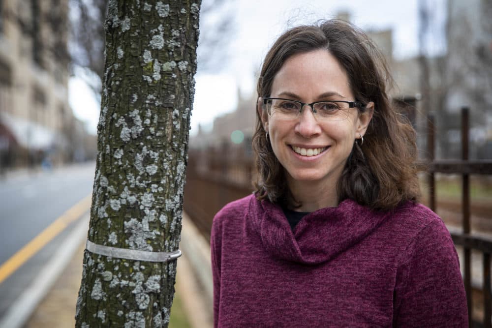 Biology professor Pam Templer stands by a banded pear tree on Commonwealth Avenue. The band expands as the tree grows, allowing Templer to measure its progress. (Robin Lubbock/WBUR)