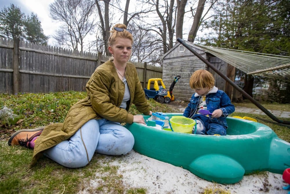 Emily Boyle sits with her three-year-old son Rowan in their backyard. (Jesse Costa/WBUR)