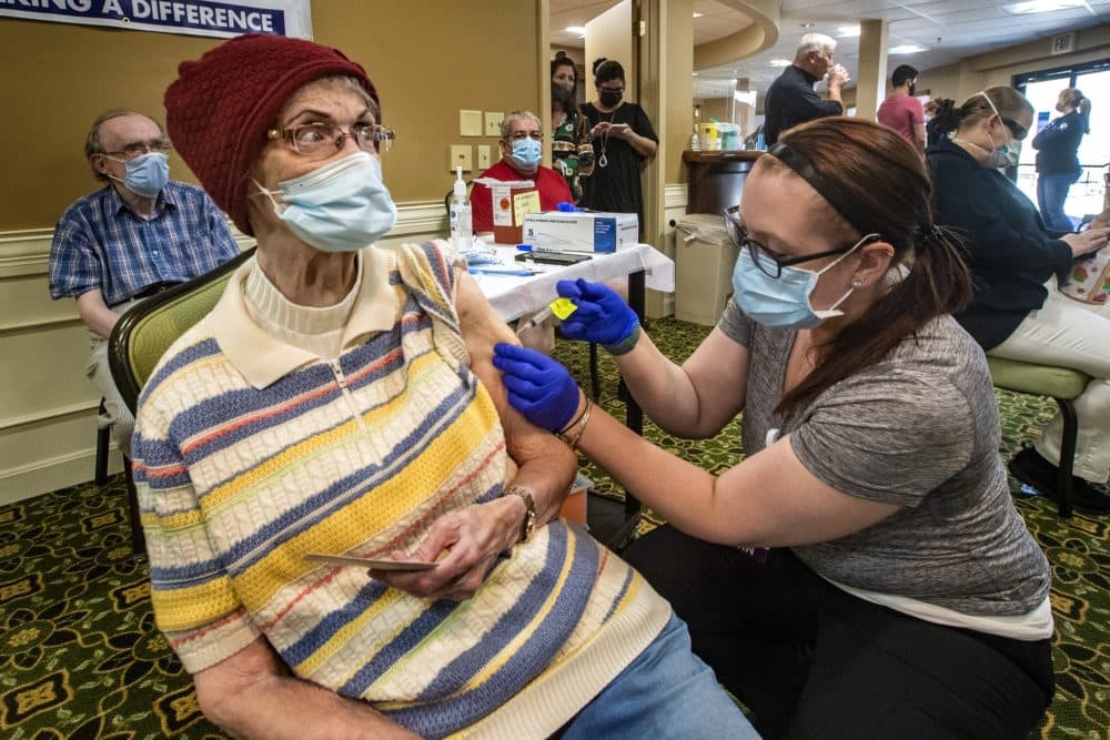 Coes Pond Senior Apartment resident Jeene Collins receives her second dose of the Moderna vaccine from medical student Bethany Morrill. (Jesse Costa/WBUR)