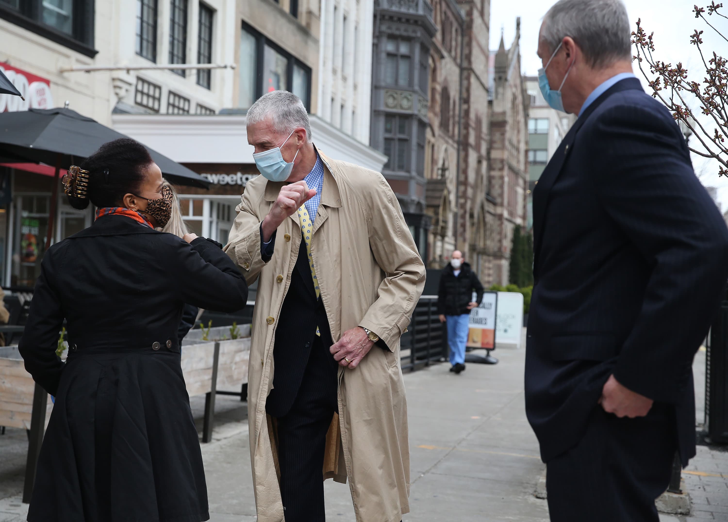 Gov. Charlie Baker watches as Acting Mayor Kim Janey exchange elbow bumps with Thomas Grilk, president of the B.A.A. before placing a wreath at the site of the Boston Marathon Bombing Memorial on One Boston Day, on the eighth anniversary of the Boston Marathon bombings, on April 15, 2021 in Boston, MA. (Nancy Lane/MediaNews Group/Boston Herald)