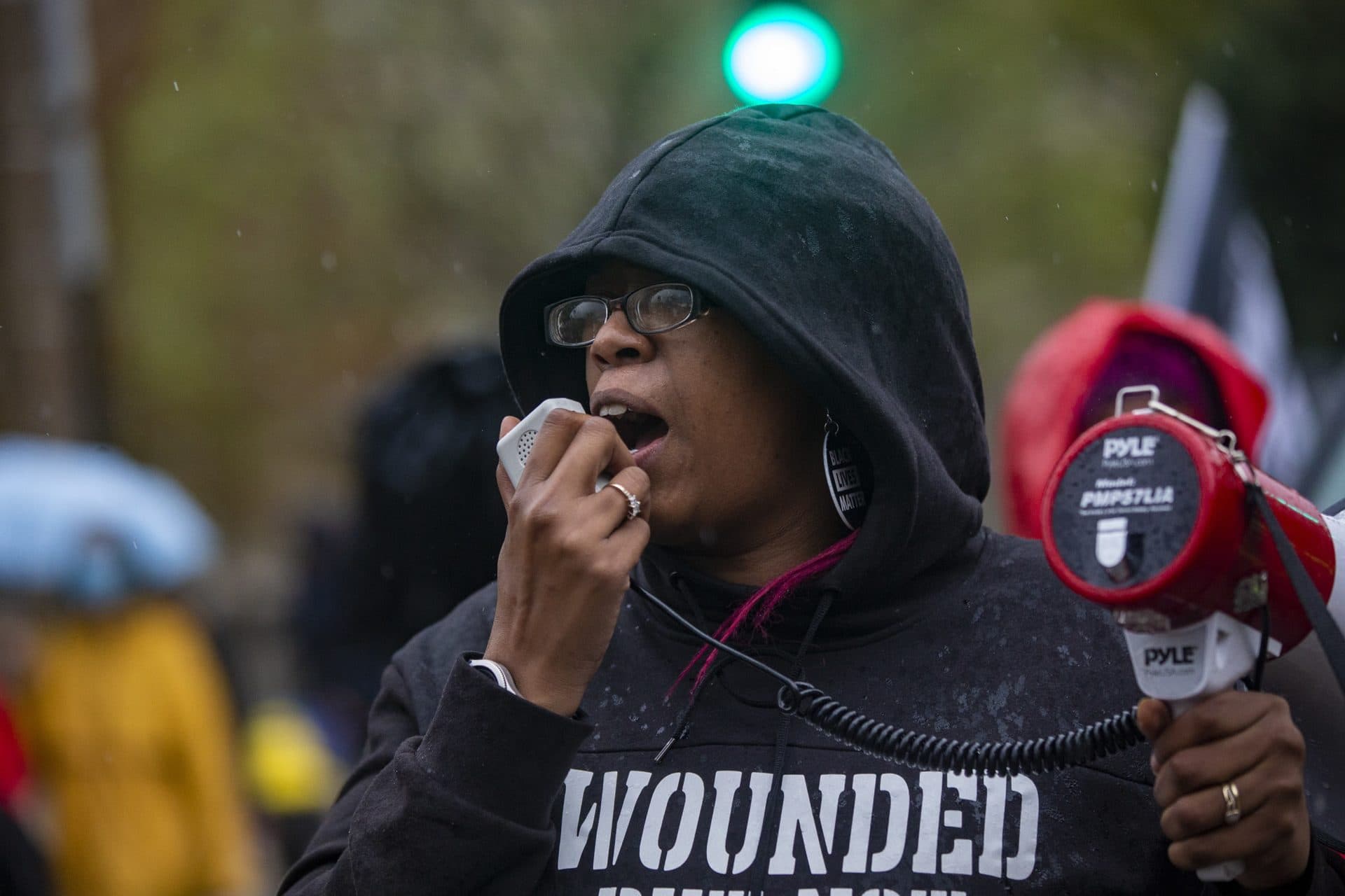 Monica Cannon-Grant leads a chant in the rain as protesters march down Malcolm X Boulevard during the Violence for Boston rally and march in Nubian Sq. (Jesse Costa/WBUR)