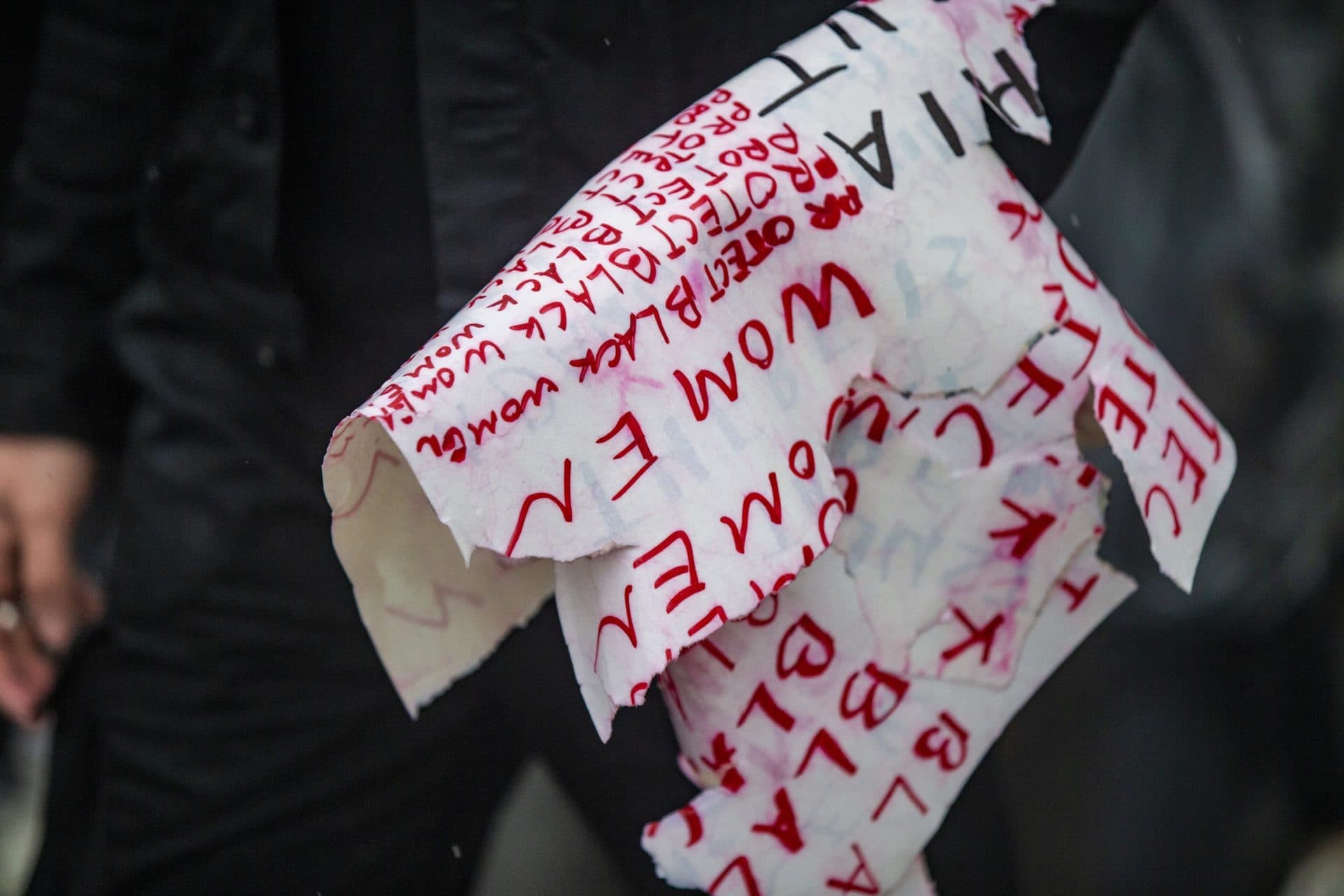 A protester carries a rain soaked and torn sign during the Violence for Boston rally and march in Nubian Sq. (Jesse Costa/WBUR)