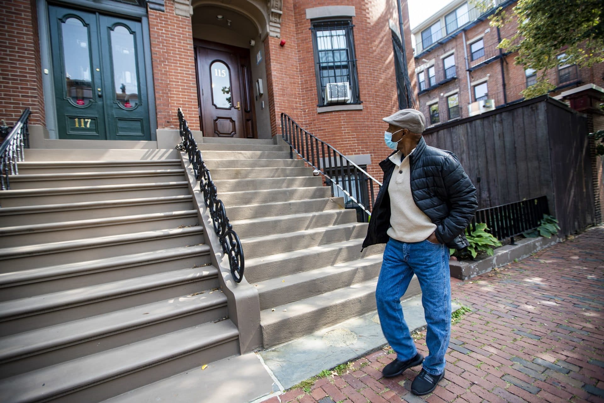 Charles Clark, of the Tenants’ Development Corporation, walks past 115 West Newton St. in the South End, one of the affordable housing properties managed by the corporation. (Jesse Costa/WBUR)