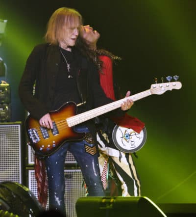 Aerosmith bassist Tom Hamilton, performing beside Steven Tyler in 2019, says the band's touring schedule is on hold. (Photo by Robb Cohen/Invision/AP)