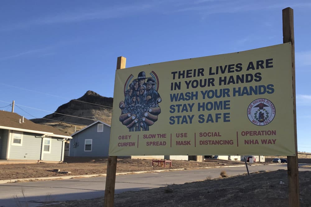 A sign urging safety measures during the pandemic is seen in Teesto, Arizona, on the Navajo Nation on Feb. 11, 2021. (Felicia Fonseca/AP)