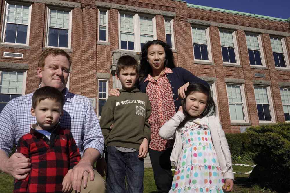 John Horrigan, top left, and his wife Kim Horrigan, top right, stand for a photograph with their children, from the left, William, 3, Conor, 8, and Sofia, 4, all of Quincy, Mass., outside Montclair Elementary School, in Quincy, April 13, 2021. (Steven Senne/AP)