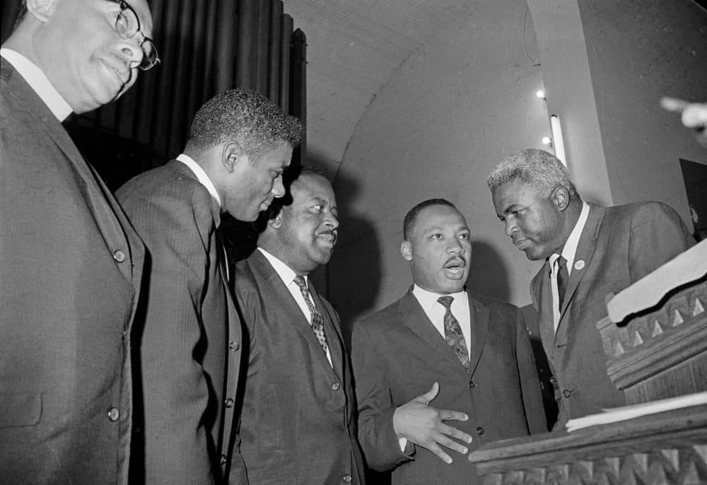 African American athletes, boxer Floyd Patterson, left, and former baseball player Jackie Robinson, right, discuss Birmingham race relations with civil rights leaders, Rev. Ralph D. Abernathy, second from left, and Rev. Martin Luther King, Jr., in Birmingham, Ala., May 14, 1963. (AP)