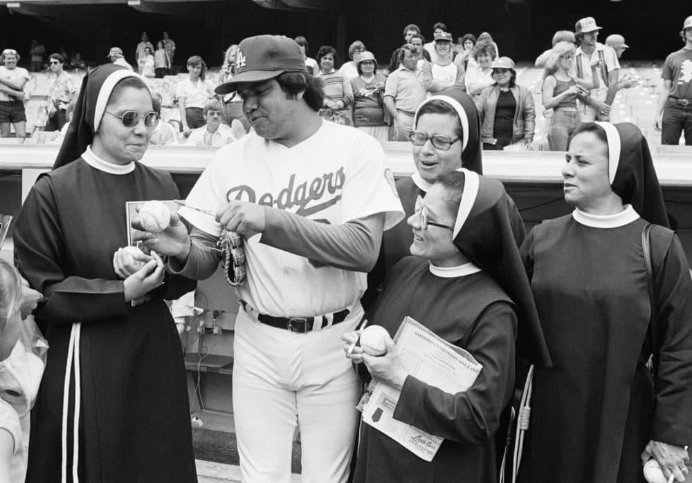 Los Angeles Dodgers rookie pitching sensation Fernando Valenzuela autographs baseballs for a group of teachers from St. Joseph's Catholic School in Placentisa Cal. on May 31, 1981 before game against the Cincinnati Reds in Los Angles. (AP Photo/Ramussen)