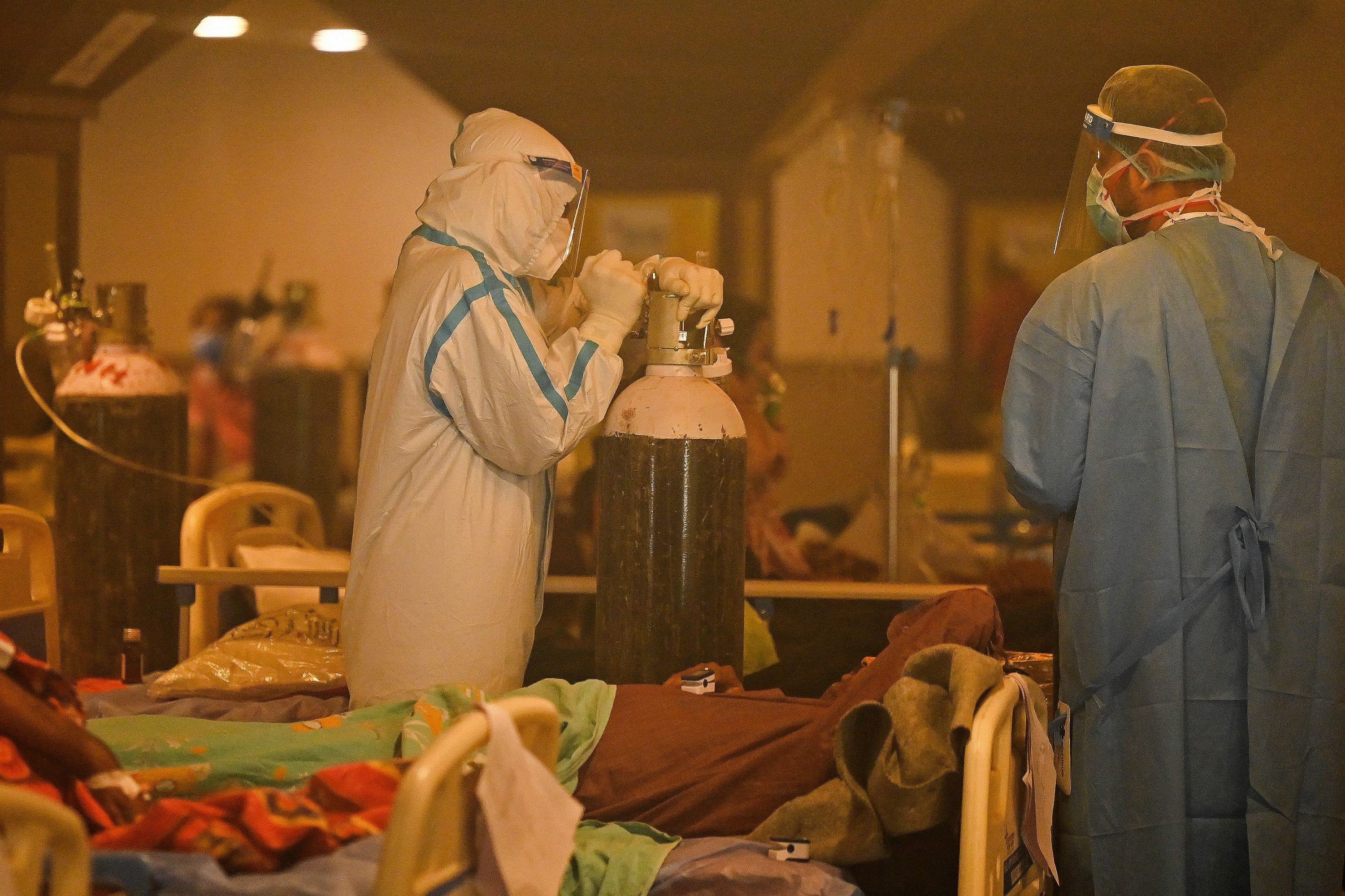 Health workers attend to COVID-19 patients inside a banquet hall temporarily converted into a covid care centre in New Delhi on April 28, 2021. (Prakash Singh/AFP via Getty Images)