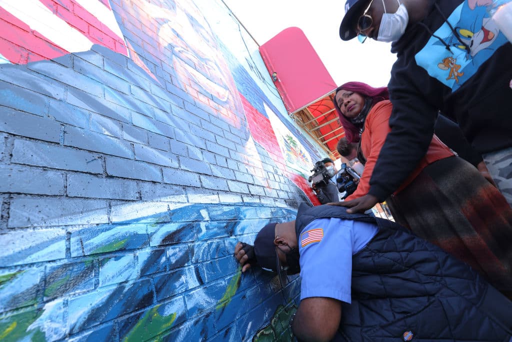 Terrence Floyd, the brother of George Floyd, kneels as he takes a moment in front of his brother's mural during a candlelight vigil in celebration of George Floyd's 47th birthday on Oct.14, 2020 in New York City. (Michael M. Santiago/Getty Images)