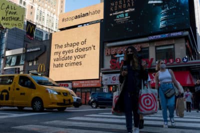 People walk past digital billboards display 'stop asian hate' messages near Penn Station on March 30, 2021 in New York City.(Alexi Rosenfeld/Getty Images)