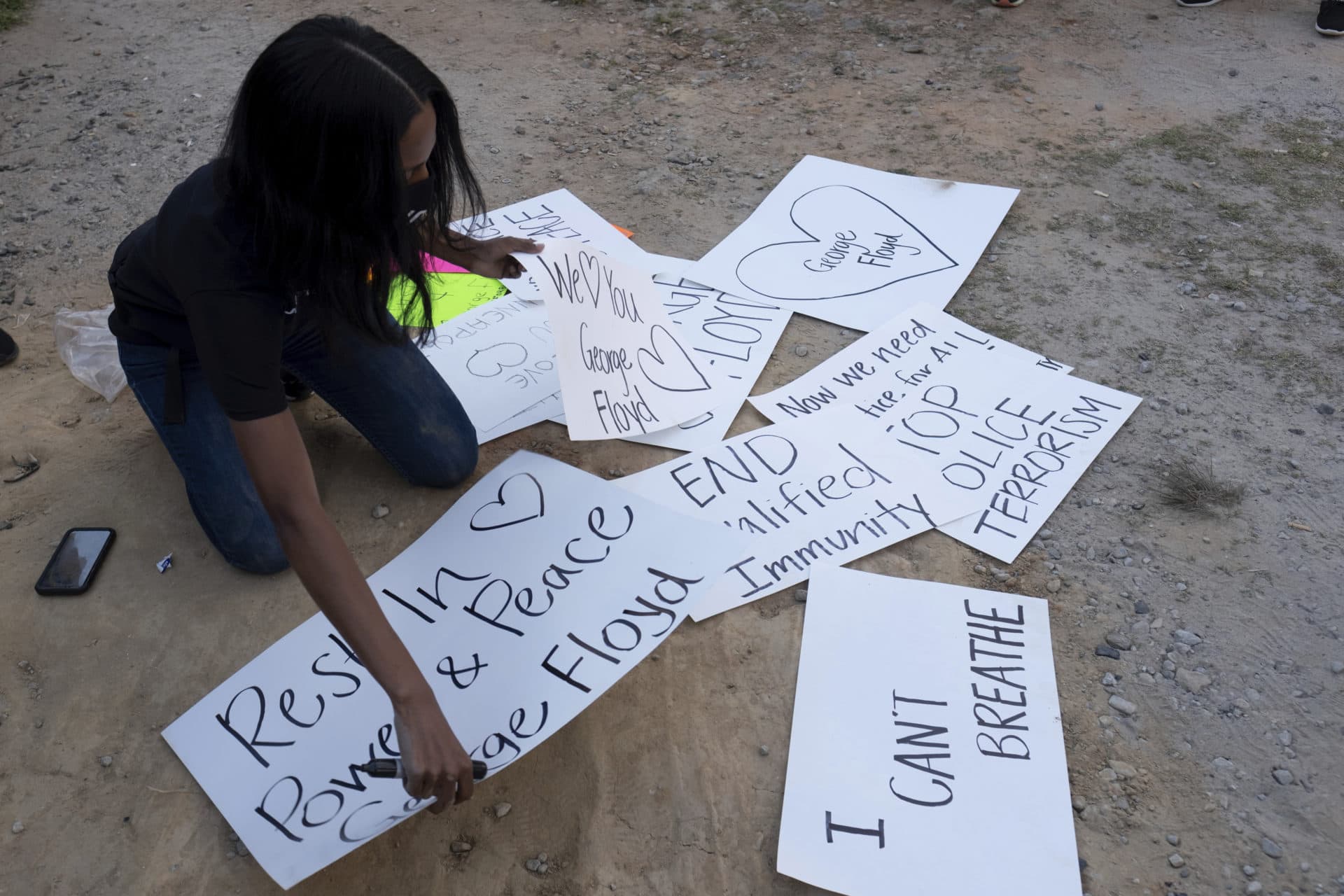 Hannah Joy Gebresilassie draws up a sign during a gathering and march in Atlanta on Tuesday. (Ben Gray/AP)