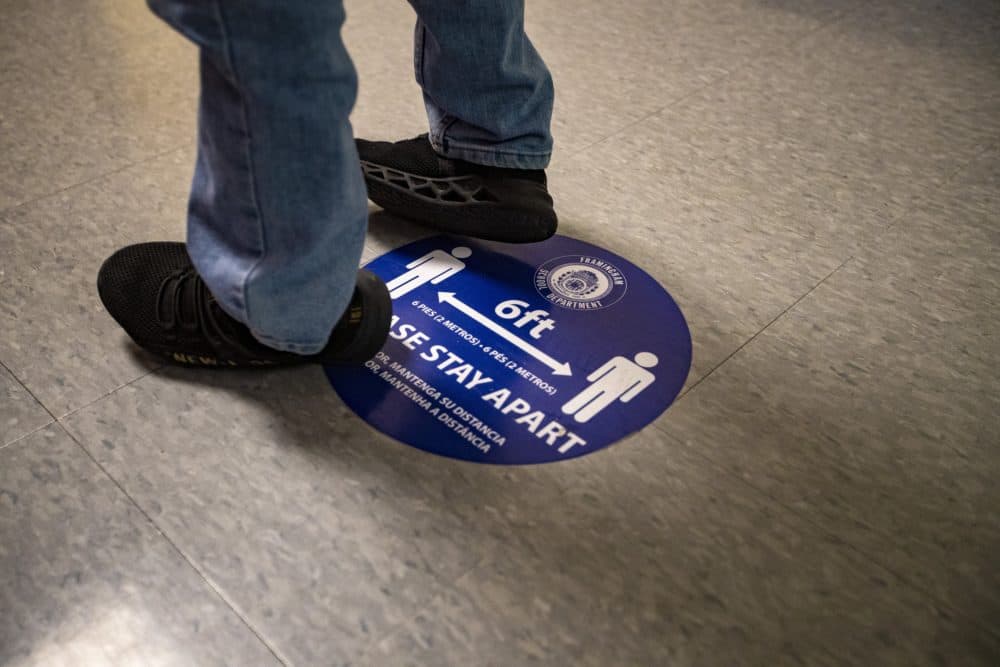 A student stands on a marker in the hallway of Barbieri Elementary School waiting for his turn to go to the restroom. (Jesse Costa/WBUR)