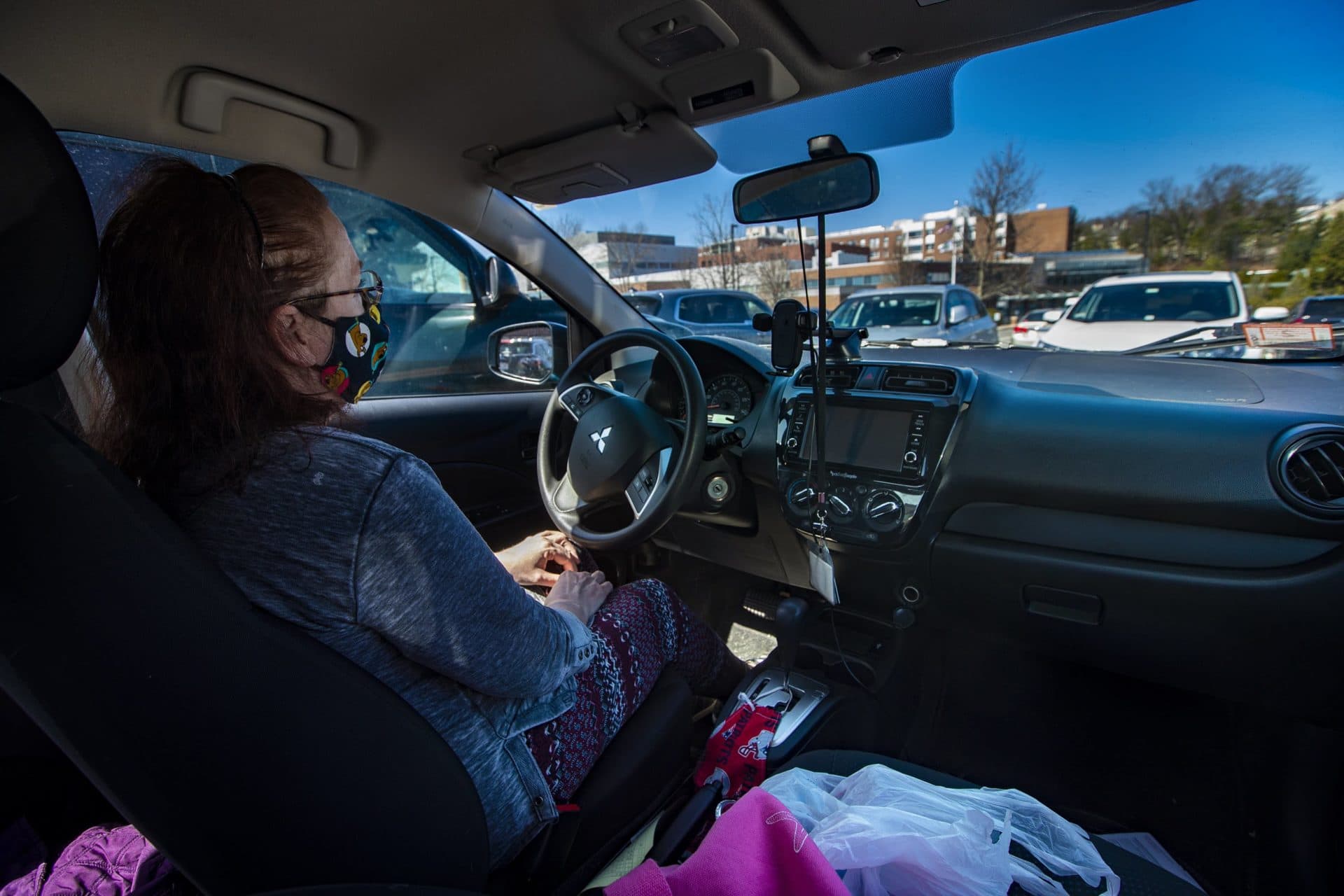 Pam pauses for a moment in the car after pulling into the parking lot of the hospital for a visit with her daughter. (Jesse Costa/WBUR)