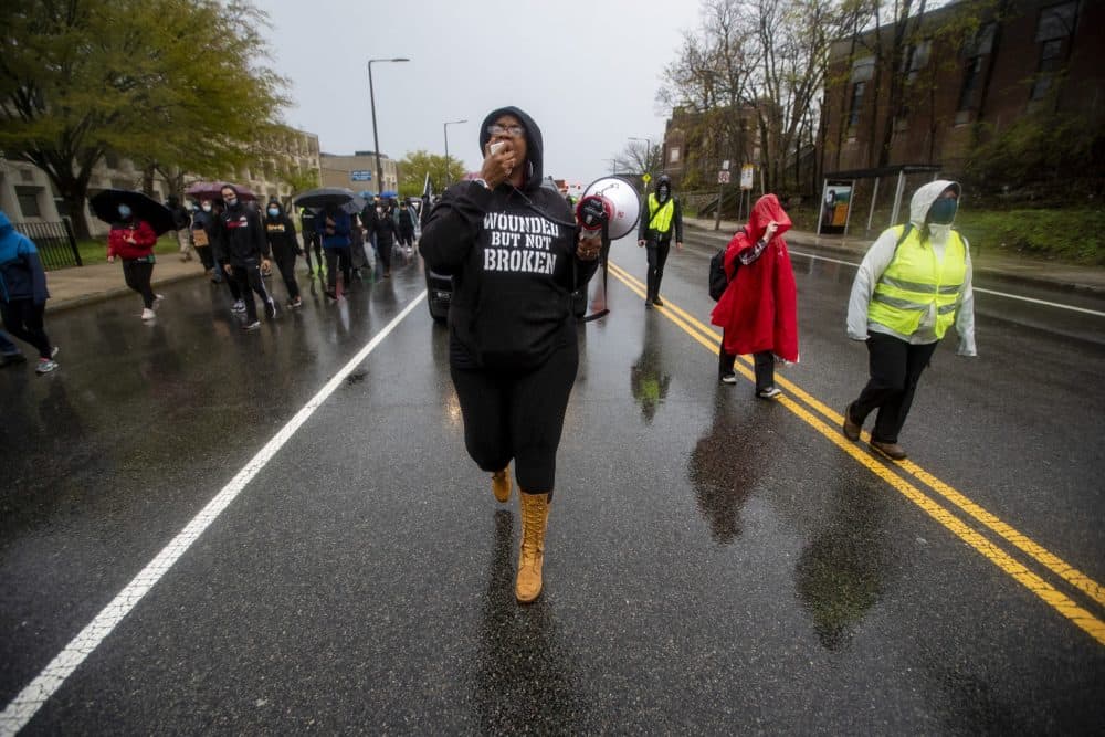Monica Cannon-Grant leads protesters in the rain down Malcolm X Boulevard. (Jesse Costa/WBUR)