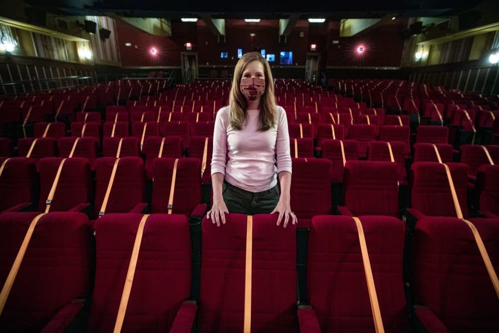Director of development and marketing Beth Gilligan, stands inside the Coolidge Corner Theatre, where the seating is outfitted with straps to prevent people from sitting to facilitate social distancing. (Jesse Costa/WBUR)