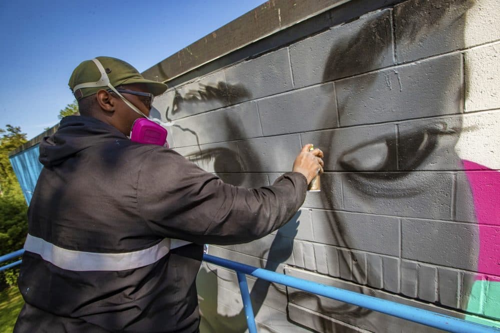 Artist Cedric Douglas works on the mural he is installing at the former Medfield State Hospital, commissioned by the Cultural Alliance of Medfield. The mural's concept centers on the healing power of music, building on the hospital’s legacy of health and wellness. (Jesse Costa/WBUR)