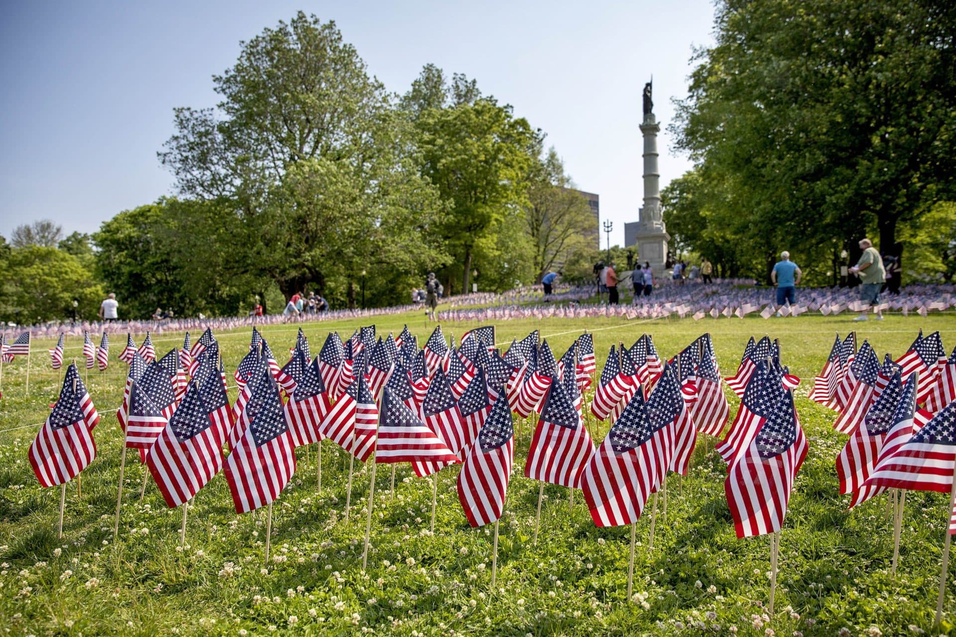 Volunteers plant memorial day flags on Boston Common. (Robin Lubbock/WBUR)