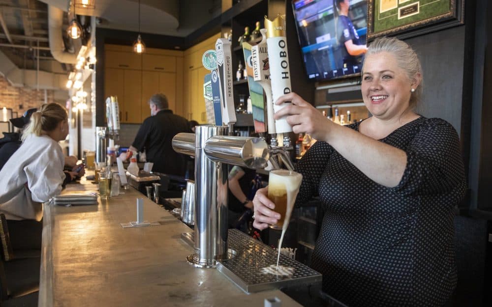 Kimberly Sapp, general manager of the A&amp;B Kitchen • Bar, draws a beer from the tap on Saturday. (Robin Lubbock/WBUR)