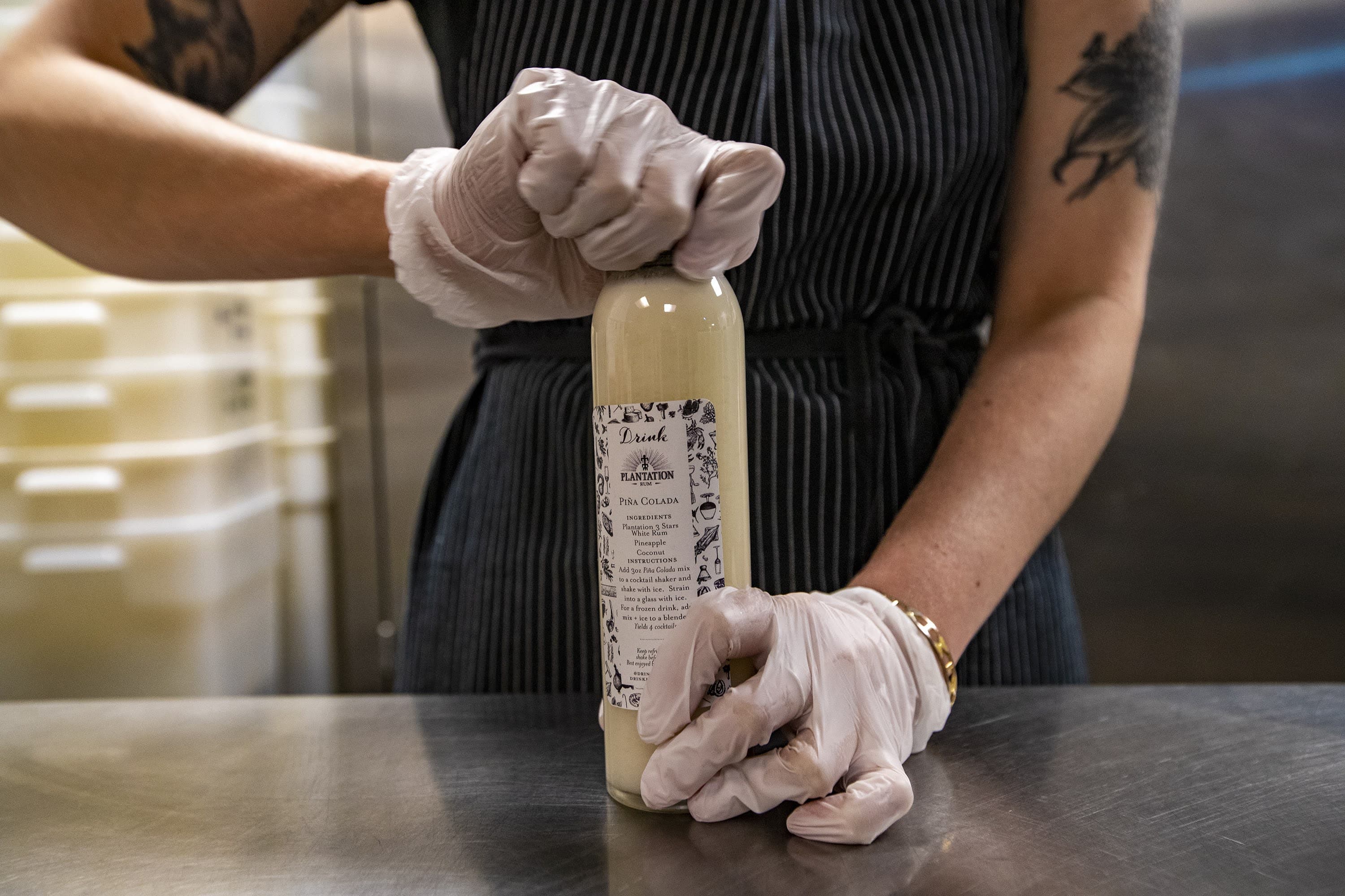 A bartender prepares a to-go cocktail. (Jesse Costa/WBUR)