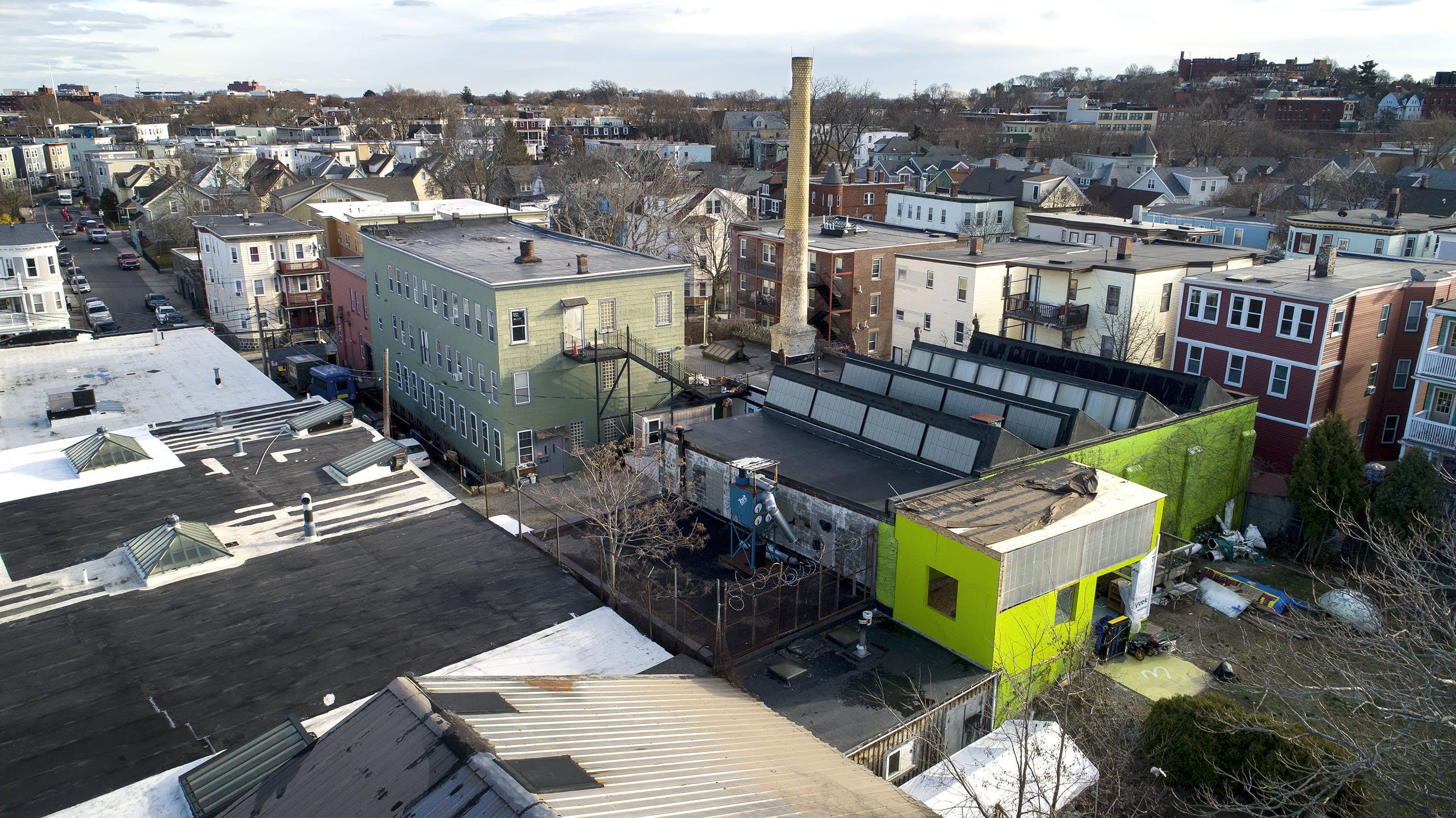 Humphreys Street Studios, with their landmark chimney and mostly green painted buildings, which were once a laundry facility in Dorchester, Mass. (Robin Lubbock/WBUR)