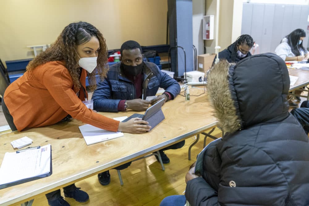 Crismely Tinidad, left, the Housing Service Coordinator at the Bronx River Community Center, translates for a resident who only speaks Spanish as he registers with a Somos Community Care screener at a pop-up COVID-19 vaccination site at the Bronx River Addition NYCHA complex, Sunday, Jan. 31, 2021. (AP Photo/Mary Altaffer)