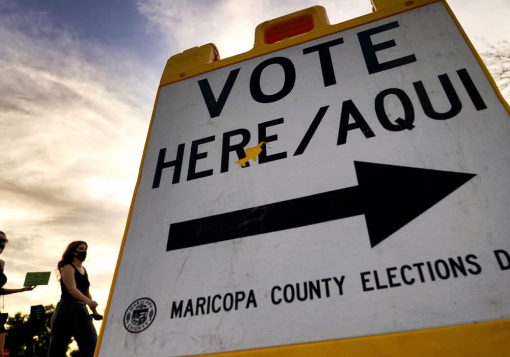 Voters deliver their ballot to a polling station in Tempe, Ariz., on Nov. 3, 2020, (Matt York/AP)
