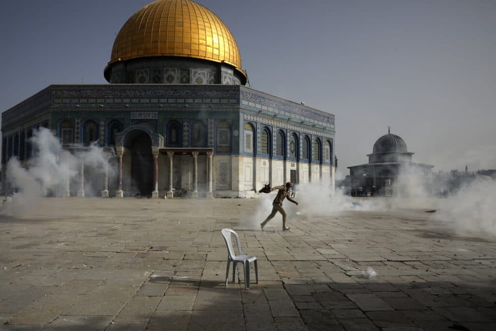 A Palestinian man runs away from tear gas during clashes with Israeli security forces in front of the Dome of the Rock Mosque at the Al Aqsa Mosque compound in Jerusalem's Old City Monday, May 10, 2021.  (Mahmoud Illean/AP)