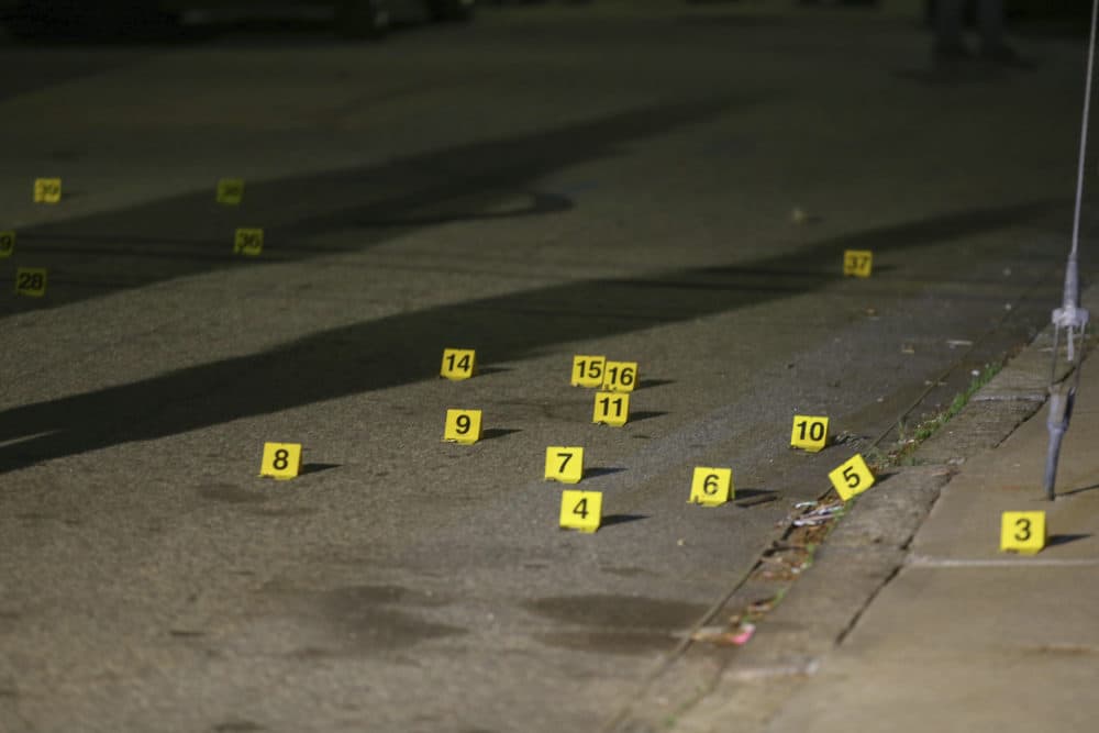 Evidence markers line the street outside a house on Carolina Avenue after the shooting, May 13, 2021, in Providence. (Stew Milne/AP)