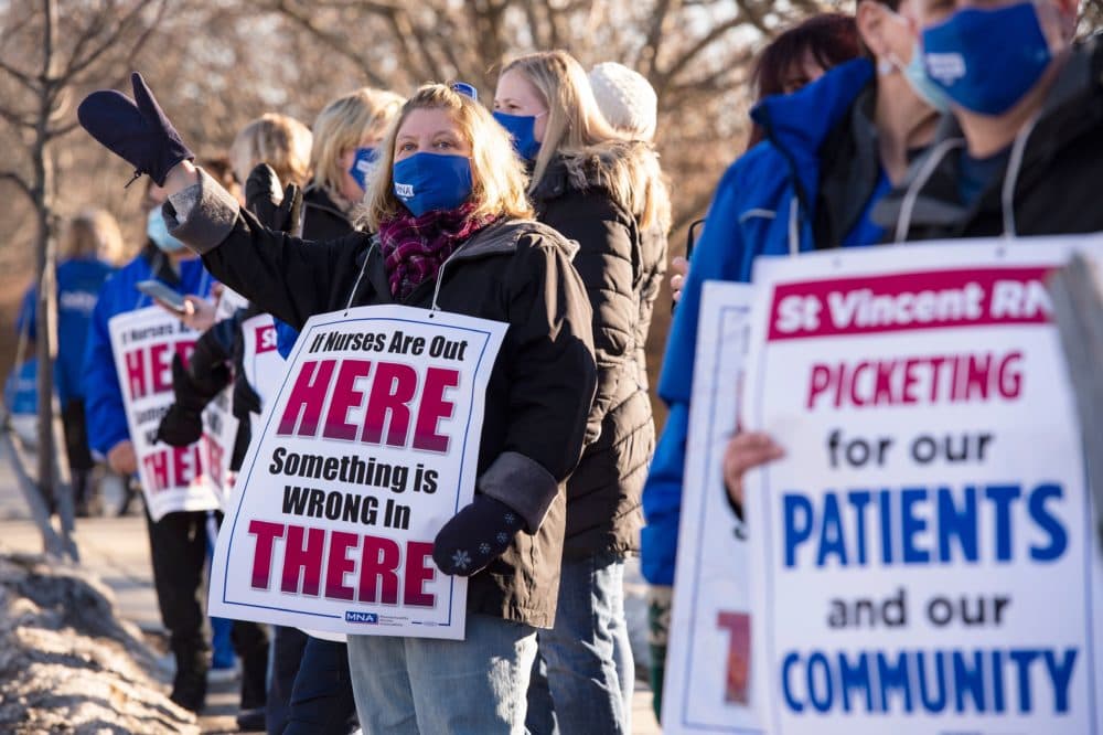 Registered Nurses and supporters stand in a picket line and wave to cars as they drive by outside St. Vincent Hospital in Worcester, Massachusetts, on Feb. 24, 2021. (Joseph Prezioso/AFP/Getty Images)