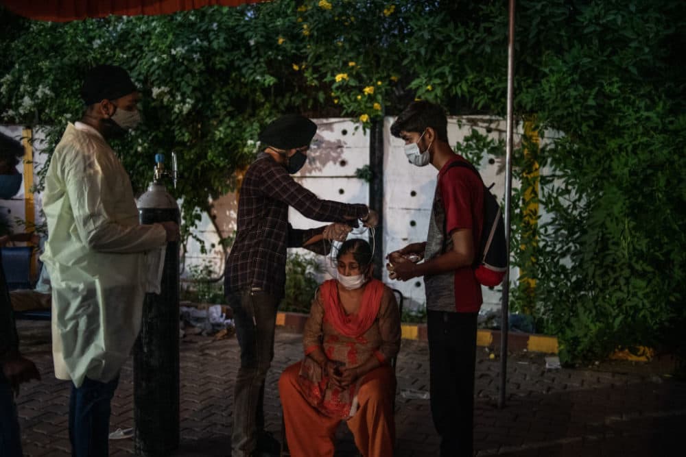 Volunteers treat patients suffering from Covid-19 with free oxygen at a makeshift clinic in a  parking lot outside the Gurdwara Damdama Sahib on May 03, 2021 in New Delhi, India. (Rebecca Conway/Getty Images)