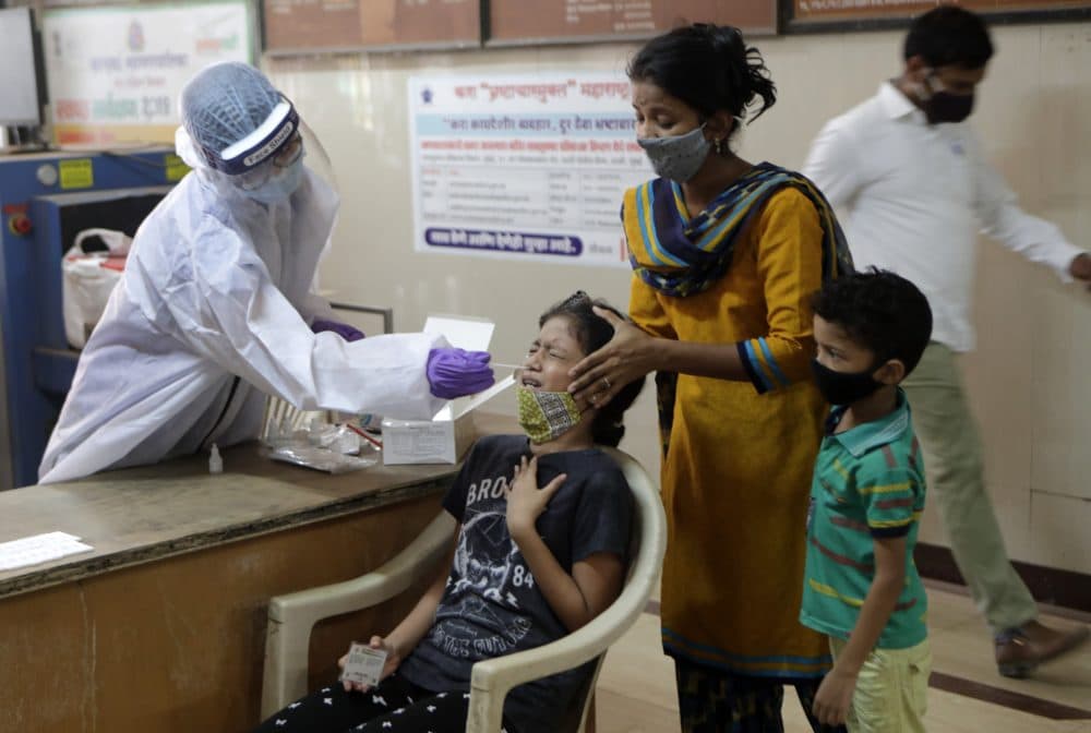 A girl reacts as a health worker collects her swab sample to test for COVID-19 in Mumbai, India, Tuesday, April 20, 2021. (Rajanish Kakade/AP)