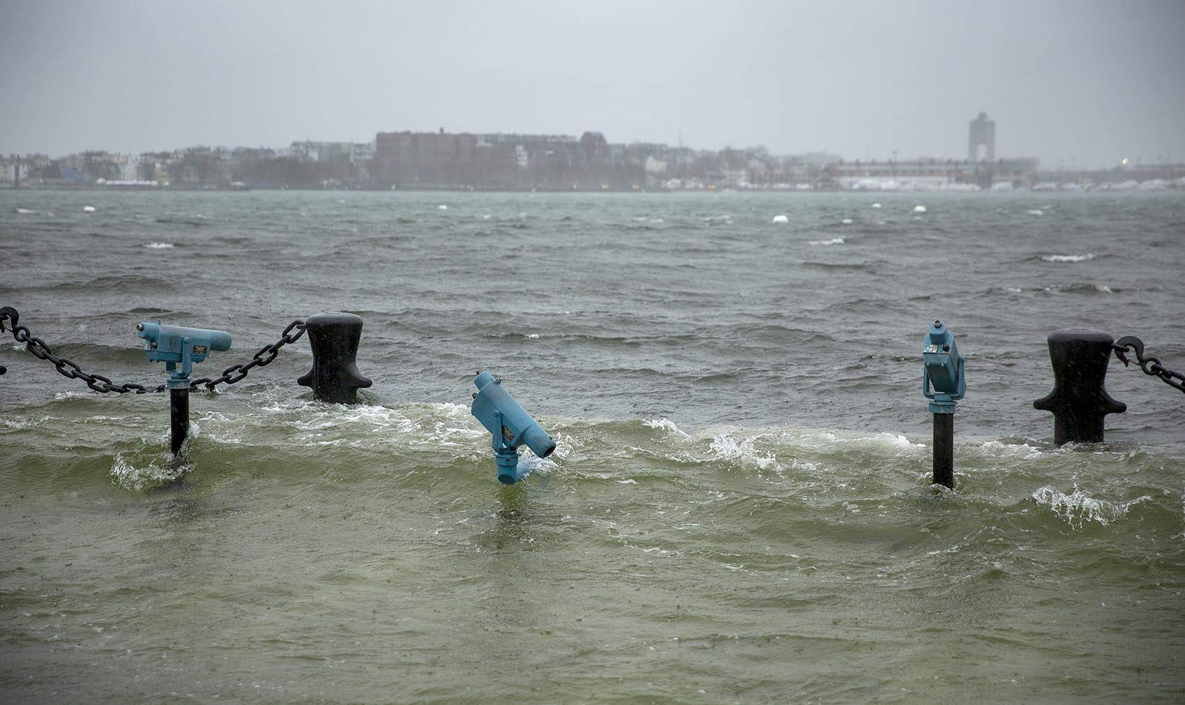 Sea water floods past the telescopes at the end of Long Wharf. (Robin Lubbock/WBUR)