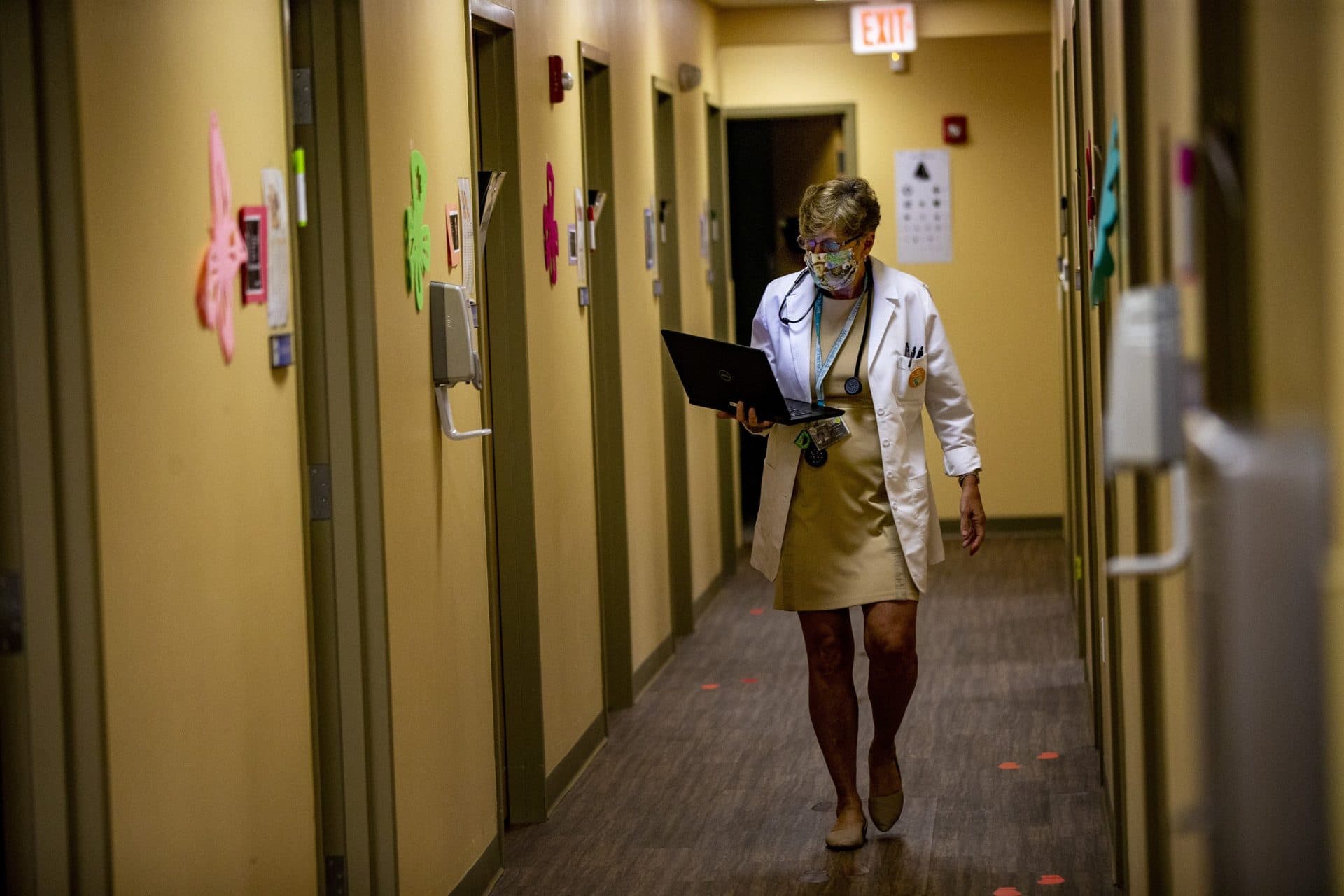 After finishing up an exam with a patient, pediatrician Dr. Janemarie Dolan walks through the corridor of Brockton Neighborhood Health Center to visit her next patient. (Jesse Costa/WBUR)