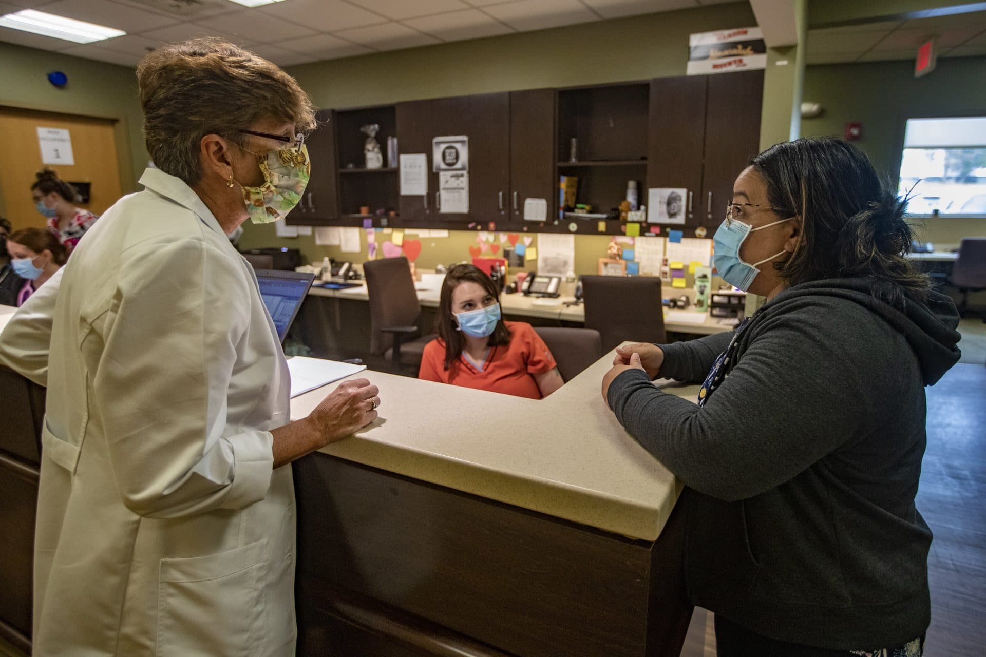 Pediatrician Dr. Janemarie Dolan speaks with community health worker Jessica Miranda about a case at the Brockton Neighborhood Health Center. (Jesse Costa/WBUR)