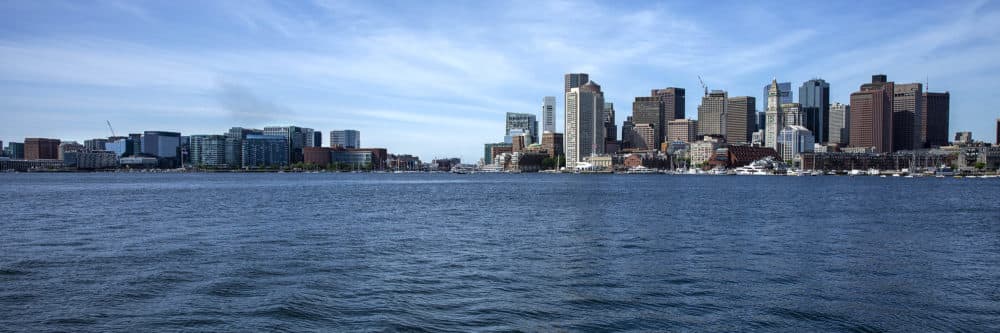 The Boston skyline seen from across the harbor with the Seaport on the left, central Boston on the right and Fort Point channel running between the two. (Robin Lubbock/WBUR)