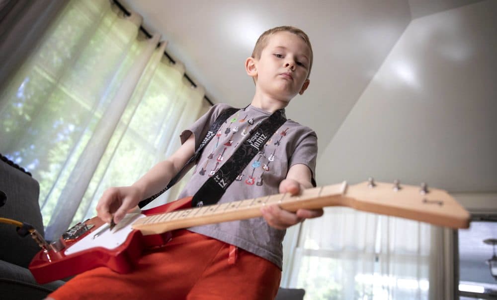 Arlen gets in some practice on his electric guitar. The young musician is the inspiration for &quot;The Boy Who Wanted to Rock,&quot; written by his father Dave Weiser. (Robin Lubbock/WBUR)