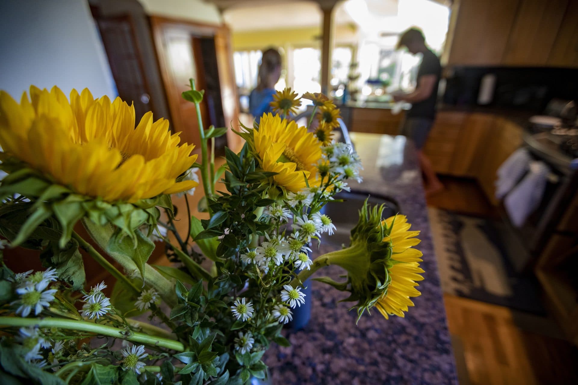 An arrangement of flowers sits in the kitchen as Karen Marmai and her son, Jackson, prepare lunch. (Jesse Costa/WBUR)